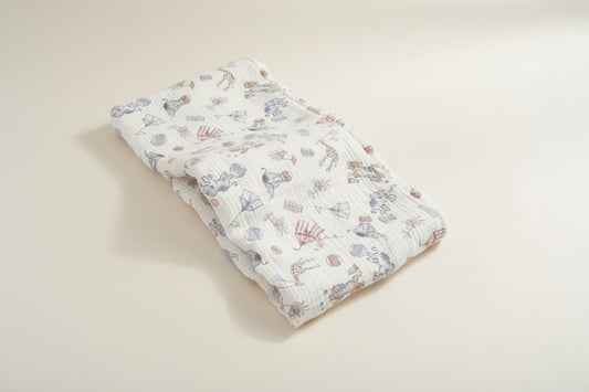 Folded baby blanket with animal pattern on a wooden surface