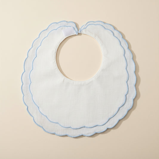 White bib with blue trim on a beige surface