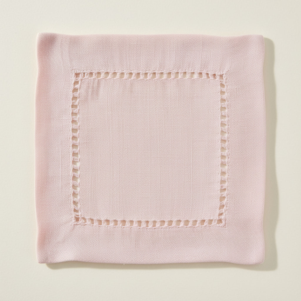Pink cocktail napkin with hemstitching on a white background