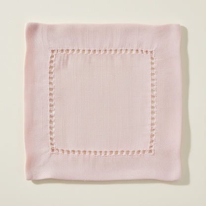 Pink cocktail napkin with hemstitching on a white background