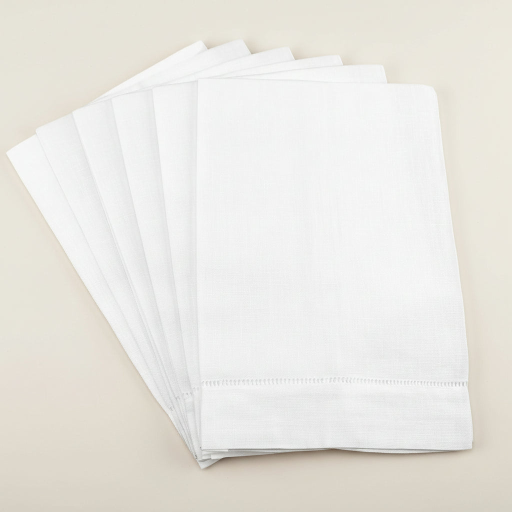 Set of white linen hemstitch towels on a white background
