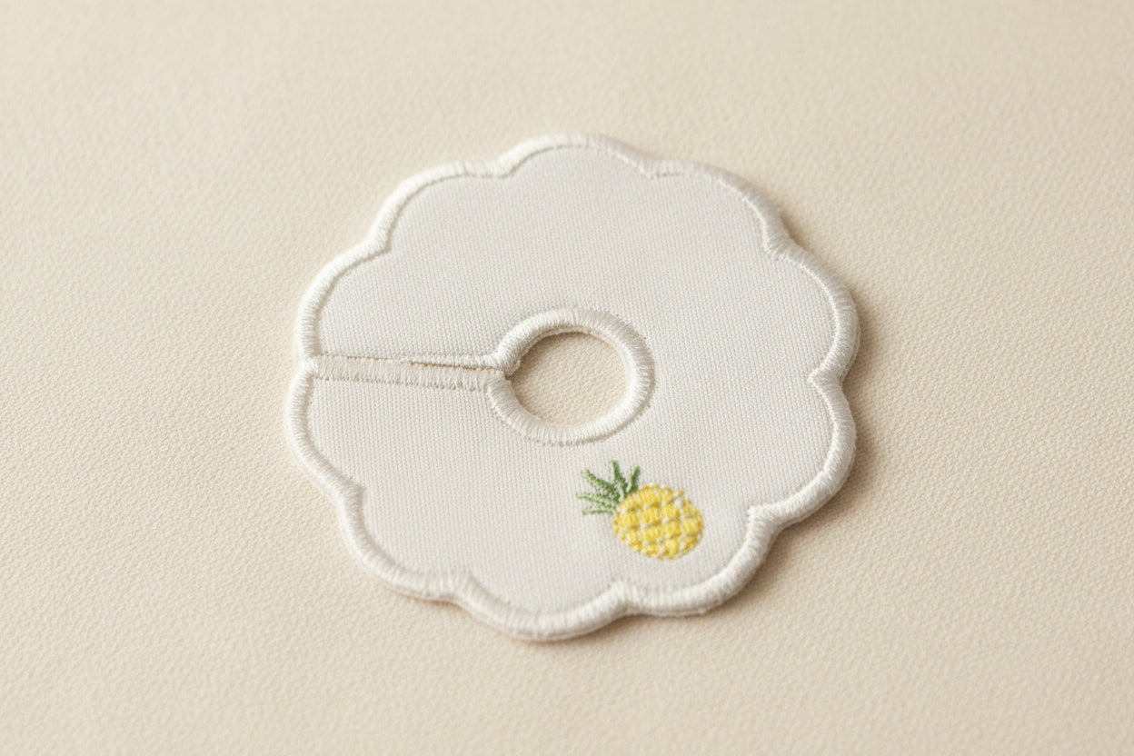 scalloped patch with pineapple embroidery on a beige background