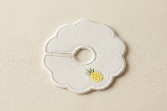 scalloped patch with pineapple embroidery on a beige background