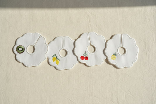 Four decorative patches with fruit illustrations on a beige background