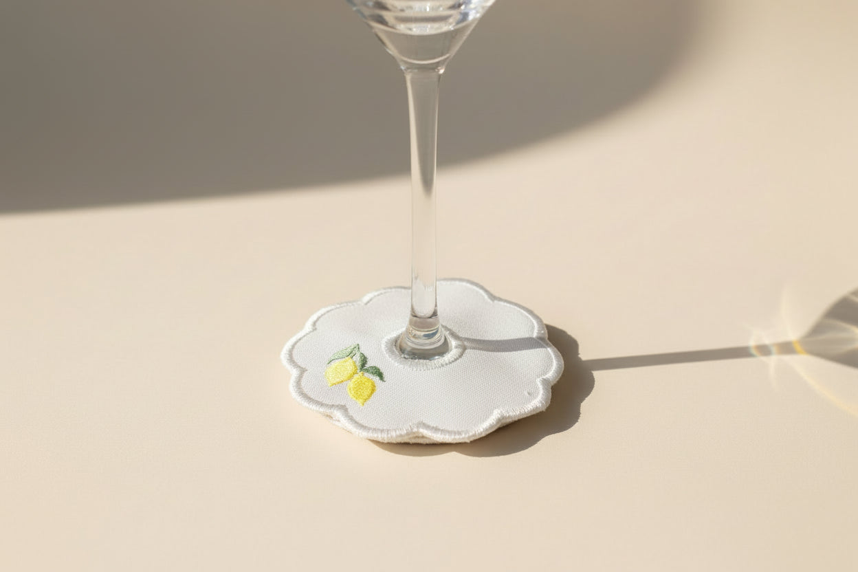 Wine glass with a decorative glass tag featuring lemon design on a beige background.