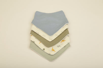 Stack of baby bibs in various colors on a warm white background