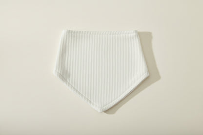 green baby bib on a warm white background