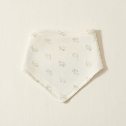 White baby bib with dinosaur designs on a warm white background 