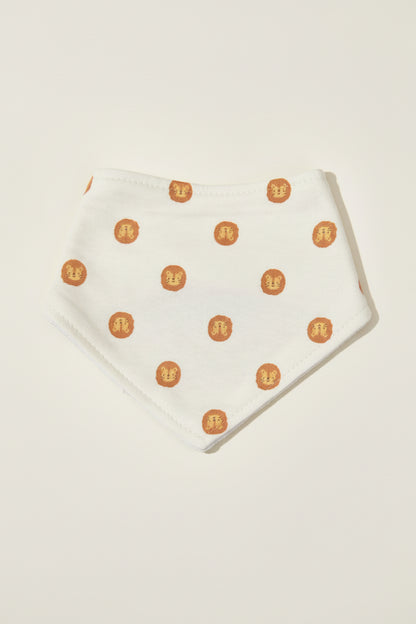 White baby bib with lion pattern on a warm white background.