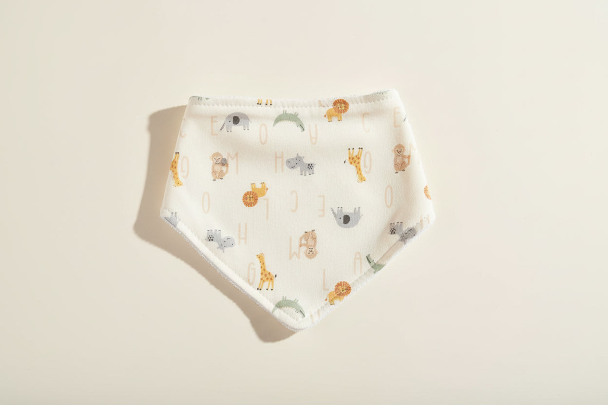 Baby bib with alphabet and animal prints on a warm white background