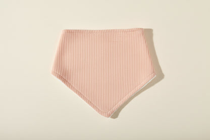 pink baby bib on a warm white background.