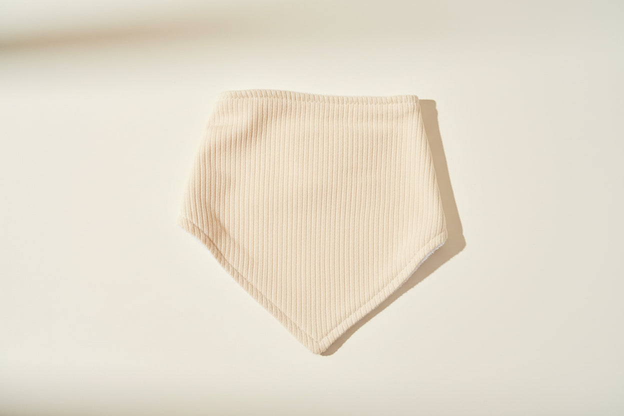 yellow baby bib on a warm white background.