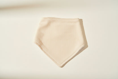 yellow baby bib on a warm white background.
