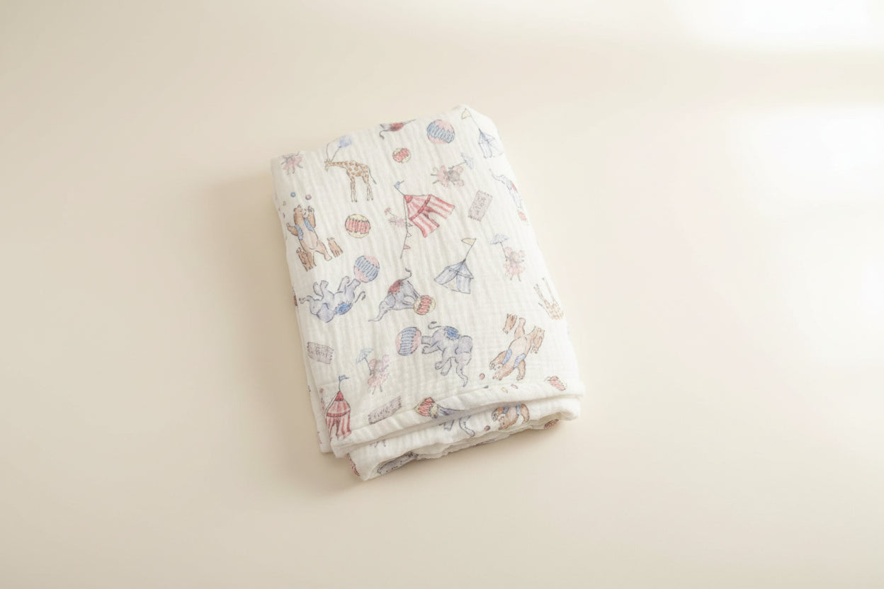 Folded baby blanket with animal pattern on a wooden surface