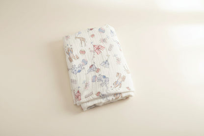 Folded baby blanket with animal pattern on a wooden surface