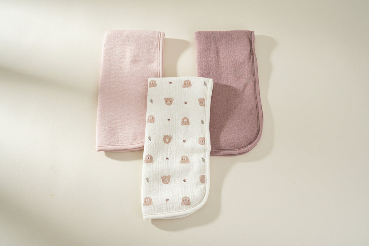 Set of three burp cloths with different colors and patterns.