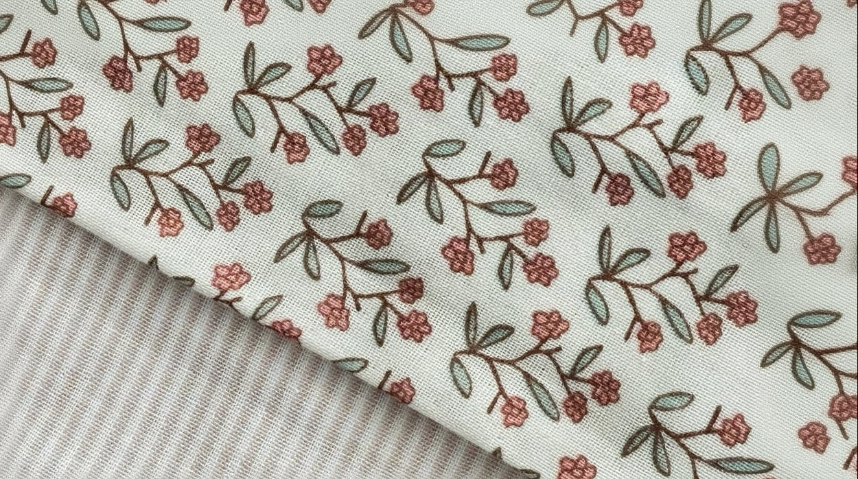 close up image of 2 baby blanket set with floral and striped design.