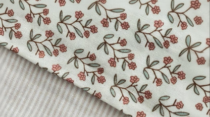 close up image of 2 baby blanket set with floral and striped design.