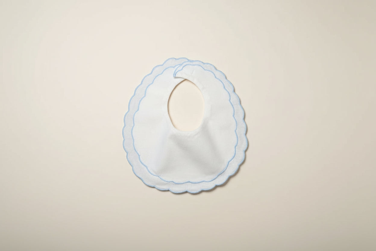 White bib with blue trim on a beige surface