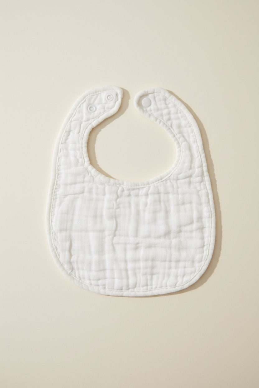 White baby bib on a wooden surface