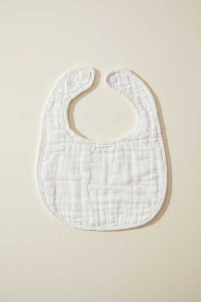 White baby bib on a wooden surface