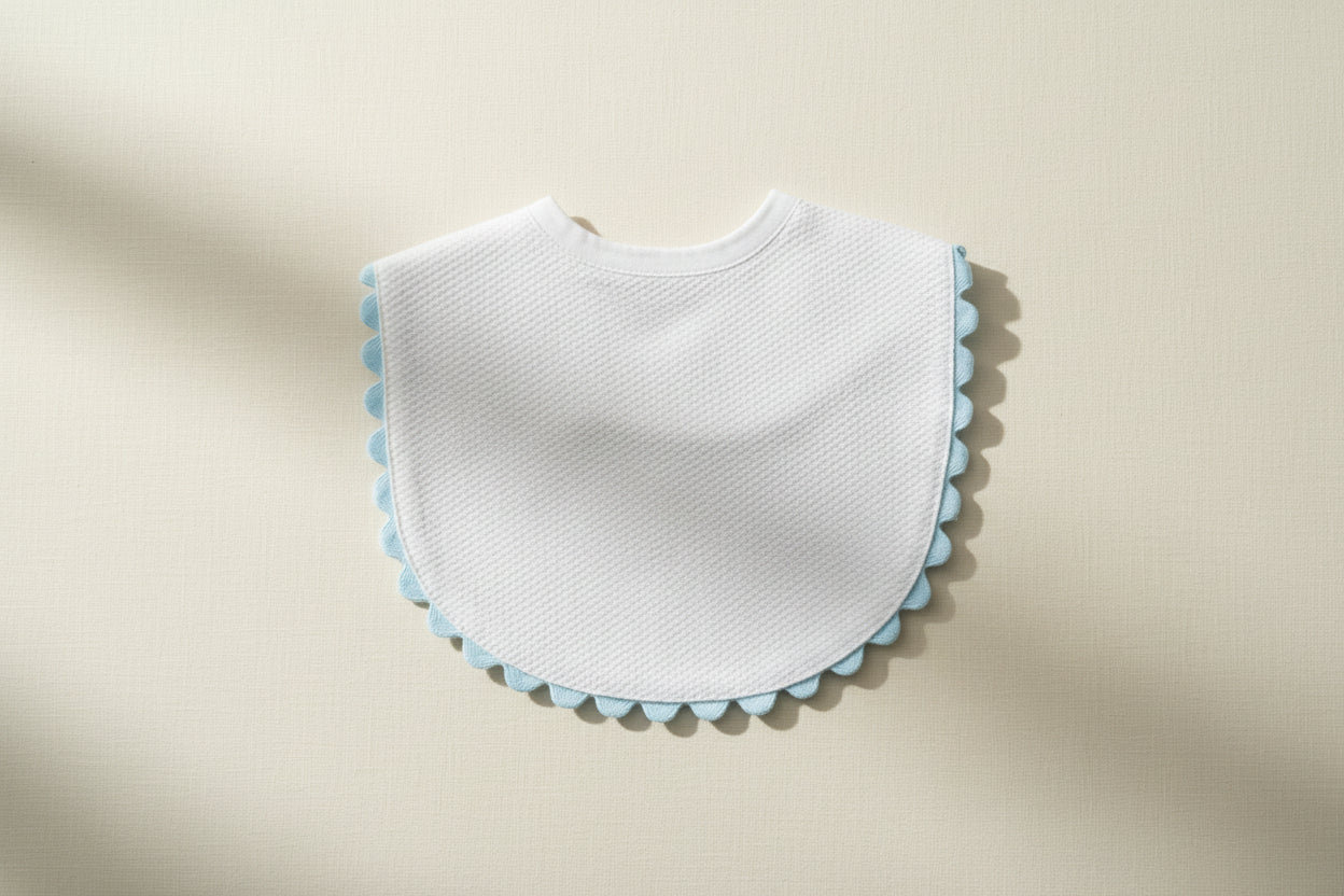 White bib with blue trim on a wooden surface