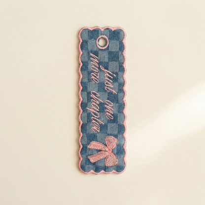 Decorative bookmark with checkered pattern and pink bow on a beige background