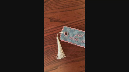 embroidered bookmark on a wooden surface.