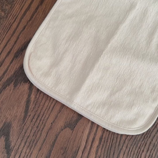 Video of set of three baby burp cloths in pink, light beige and bear pattern.