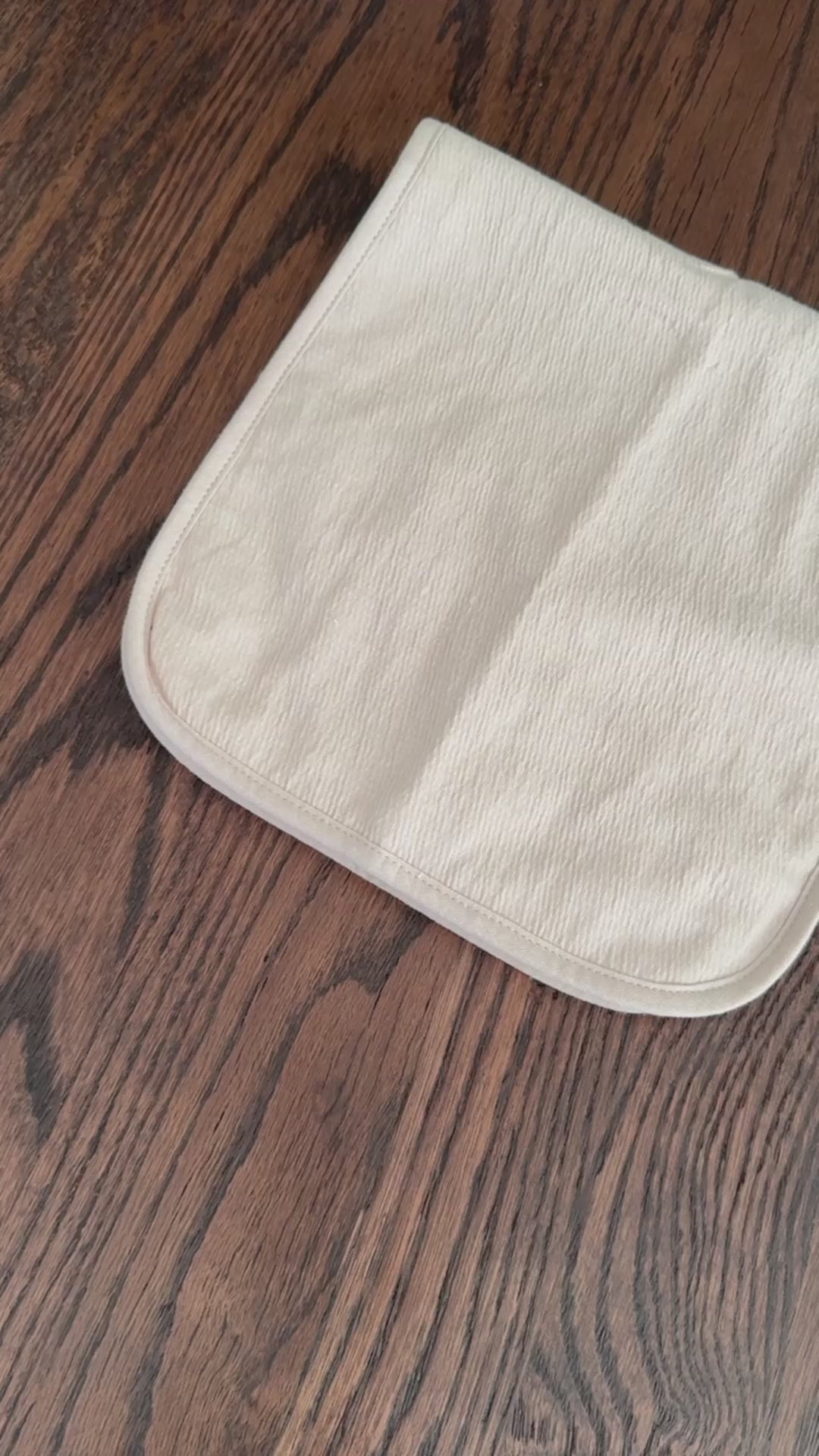 Video of set of three baby burp cloths in pink, light beige and bear pattern.