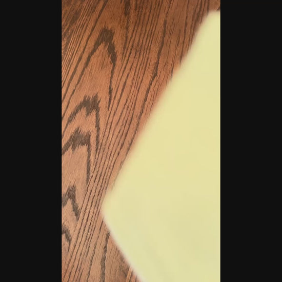 video of a set of five baby bibs with different patterns on a wooden surface.
