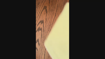 video of a set of five baby bibs with different patterns on a wooden surface.